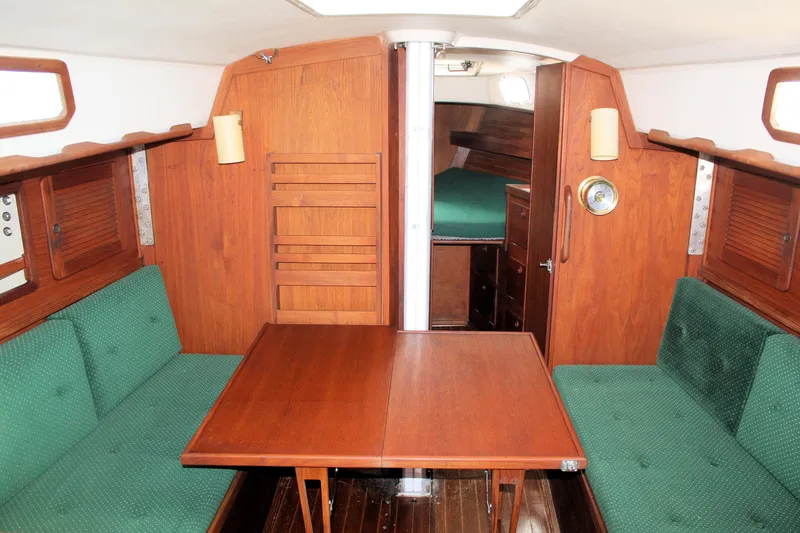 Slide: The Image of 1986 Sabre 34 MK II yacht interior with wooden table and green cushioned seating. - 27