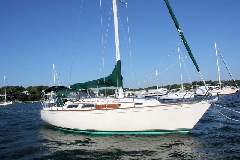Slide: The Image of 1986 Sabre 34 MK II sailboat on water, with green sail cover, under clear blue sky. - 3