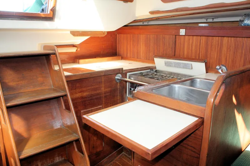 Slide: The Image of 1986 Sabre 34 MK II yacht interior with wooden cabinetry and compact kitchen area. - 33