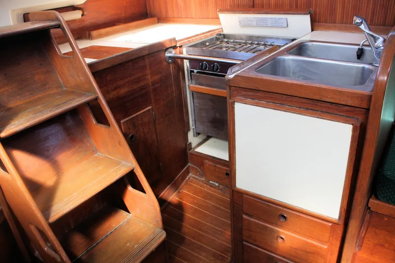 Slide: The Image of 1986 Sabre 34 MK II yacht interior with wooden stairs, stove, and sink. - 34