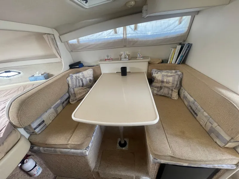 Slide: The Image of Cozy dining area inside a 1989 Californian Express boat with cushioned seating and table. - 11