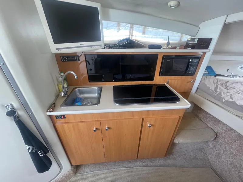 Slide: The Image of Compact kitchen area in a 1989 Californian Express boat with sink, stove, and microwave. - 12