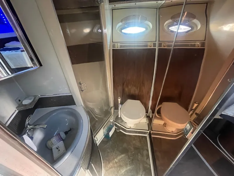 Slide: The Image of Bathroom interior of a 1989 Californian Express yacht, featuring a sink and dual toilets. - 19