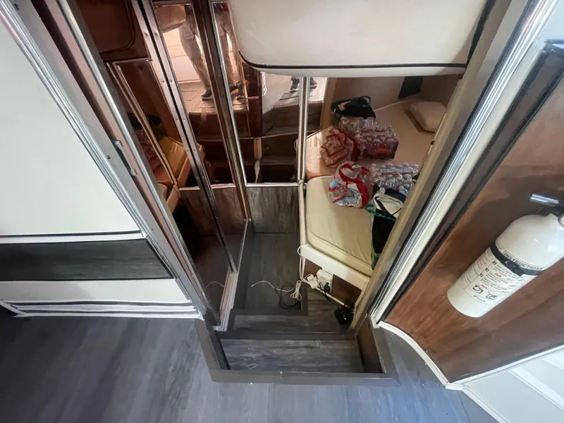 Slide: The Image of Interior of a 1989 Californian Express RV with stairs, bed, and storage items. - 20