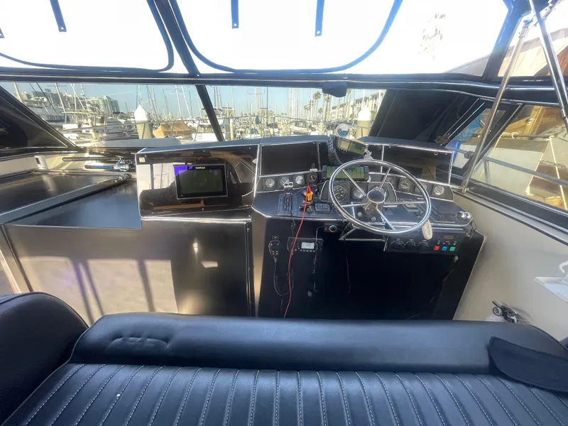 Slide: The Image of 1989 Californian Express boat cockpit with steering wheel and navigation equipment. - 23