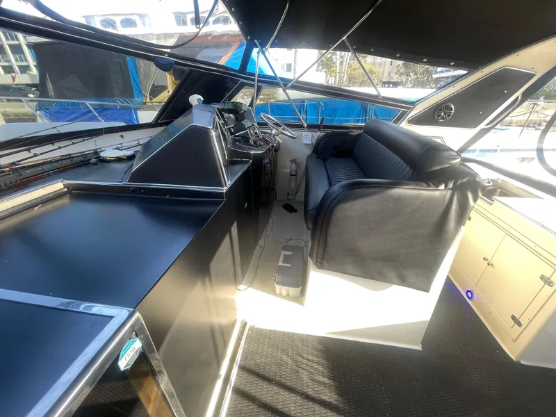 Slide: The Image of Interior of a 1989 Californian Express boat with black seating and control panel. - 24