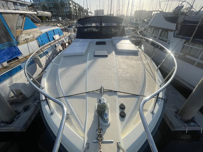 Slide: The Image of 1989 Californian Express yacht docked at marina, featuring spacious deck and modern design. - 6