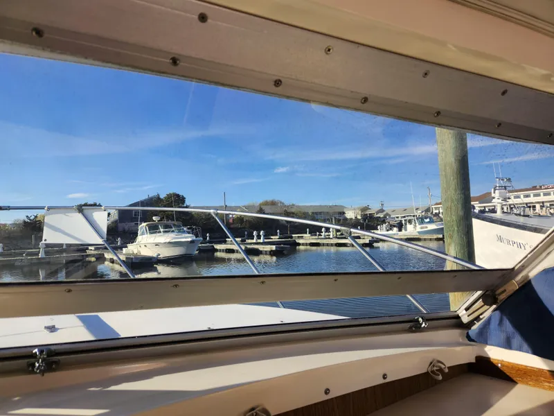 Slide: The Image of View from 1975 Bertram 28 Flybridge Cruiser, overlooking marina with boats and clear blue sky. - 14