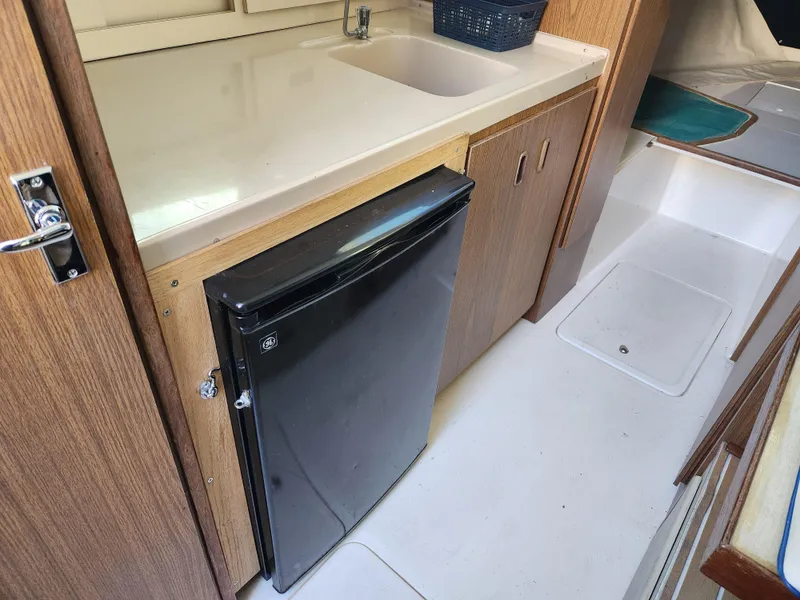 Slide: The Image of 1975 Bertram 28 Flybridge Cruiser interior with kitchenette and compact fridge. - 15