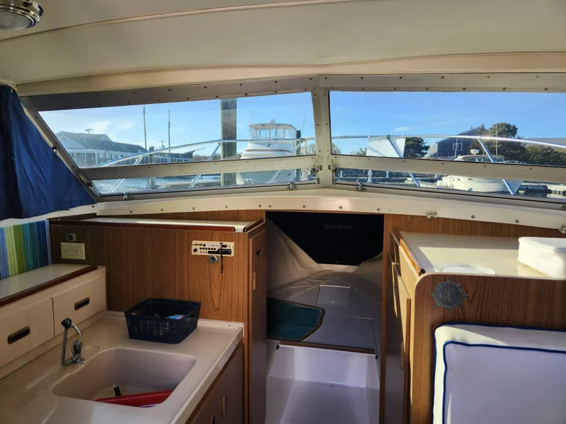 Slide: The Image of Interior view of a 1975 Bertram 28 Flybridge Cruiser, featuring a compact cabin and kitchenette. - 16