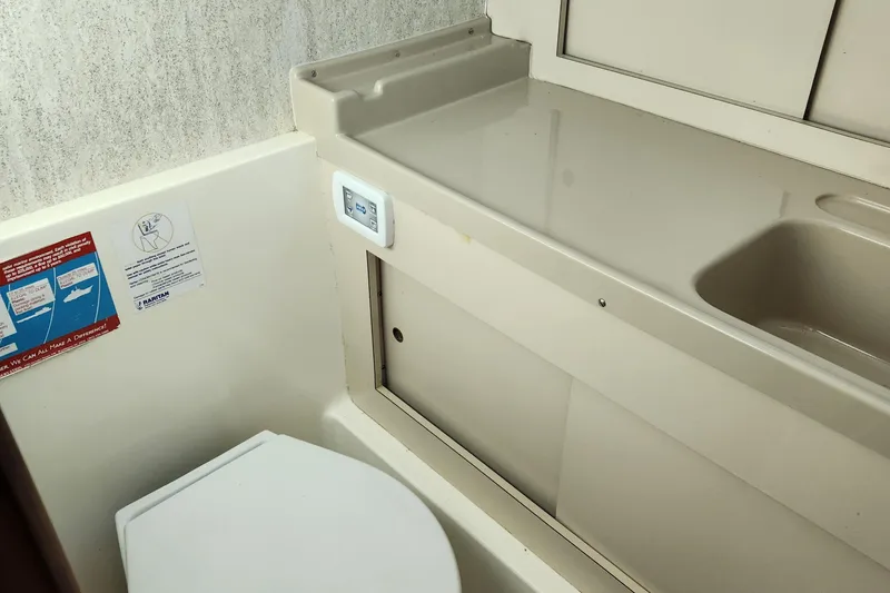 Slide: The Image of 1975 Bertram 28 Flybridge Cruiser bathroom with toilet and sink. - 17