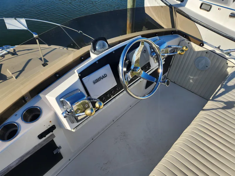 Slide: The Image of 1975 Bertram 28 Flybridge Cruiser helm with steering wheel and controls. - 20