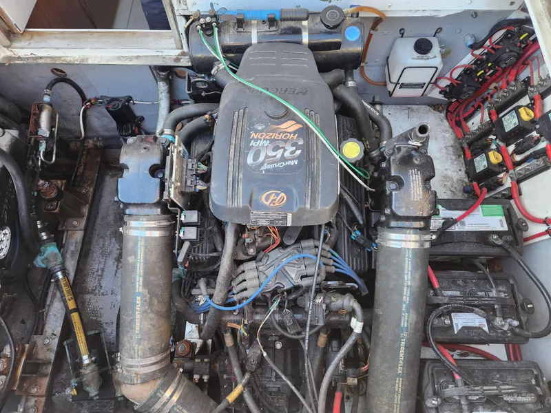 Slide: The Image of Engine compartment of a 1975 Bertram 28 Flybridge Cruiser, showcasing mechanical components and wiring. - 22