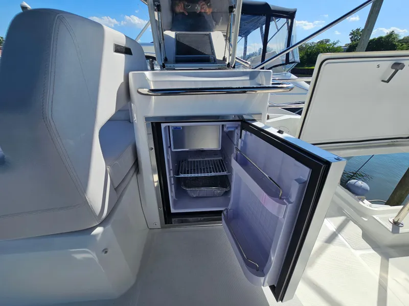 Slide: The Image of 2024 Beneteau Antares 12 boat interior with open mini fridge, showcasing modern amenities. - 15