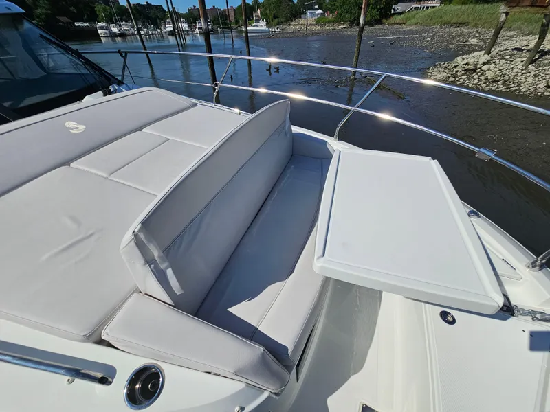 Slide: The Image of 2024 Beneteau Antares 12 boat with cushioned seating and table on deck. - 21