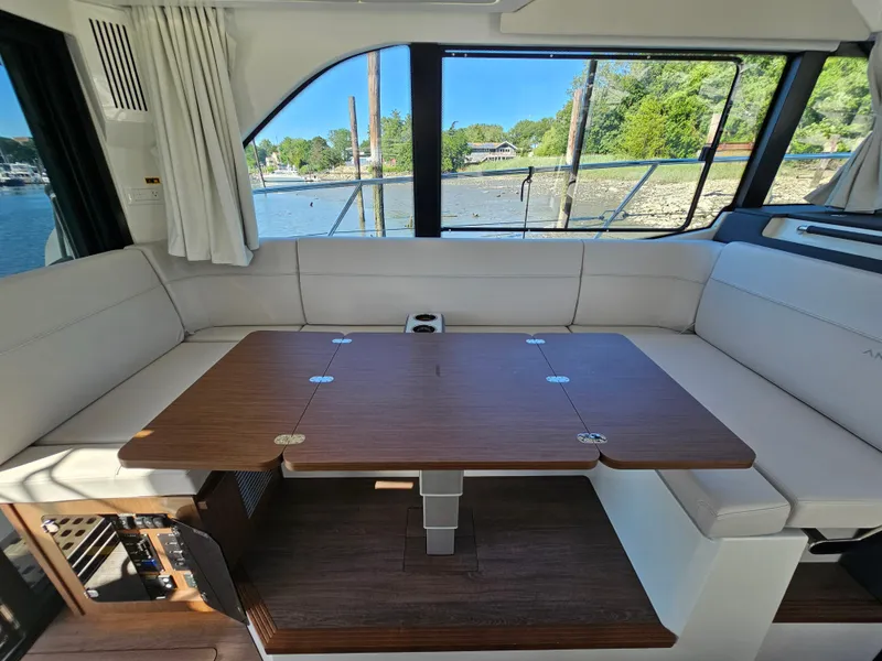 Slide: The Image of Interior of 2024 Beneteau Antares 12 yacht with elegant seating and wooden table. - 29