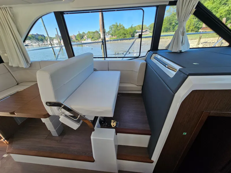 Slide: The Image of Interior of 2024 Beneteau Antares 12 yacht with seating and scenic window view. - 31