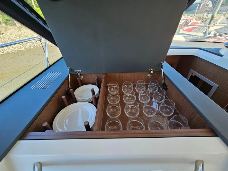 Slide: The Image of Storage compartment with glasses and plates on a 2024 Beneteau Antares 12 yacht. - 33