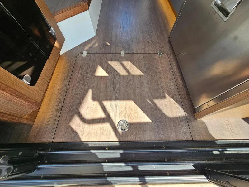 Slide: The Image of Interior view of 2024 Beneteau Antares 12, featuring sleek wooden flooring and modern design elements. - 48