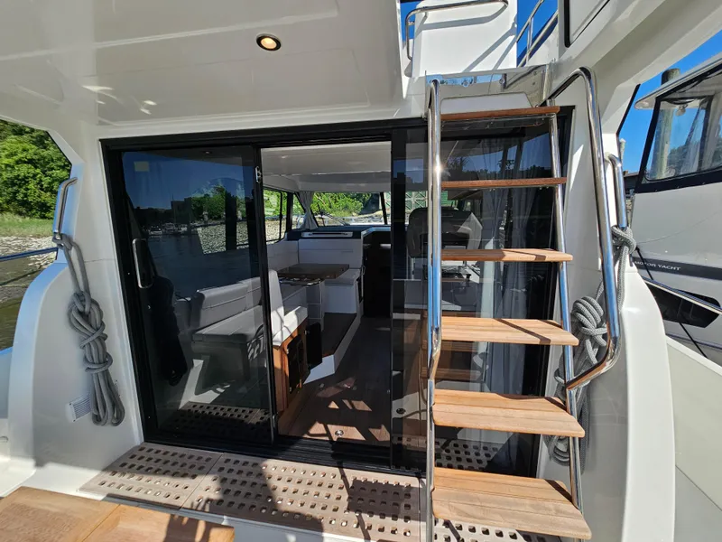 Slide: The Image of 2024 Beneteau Antares 12 yacht interior with wooden stairs and glass doors. - 7