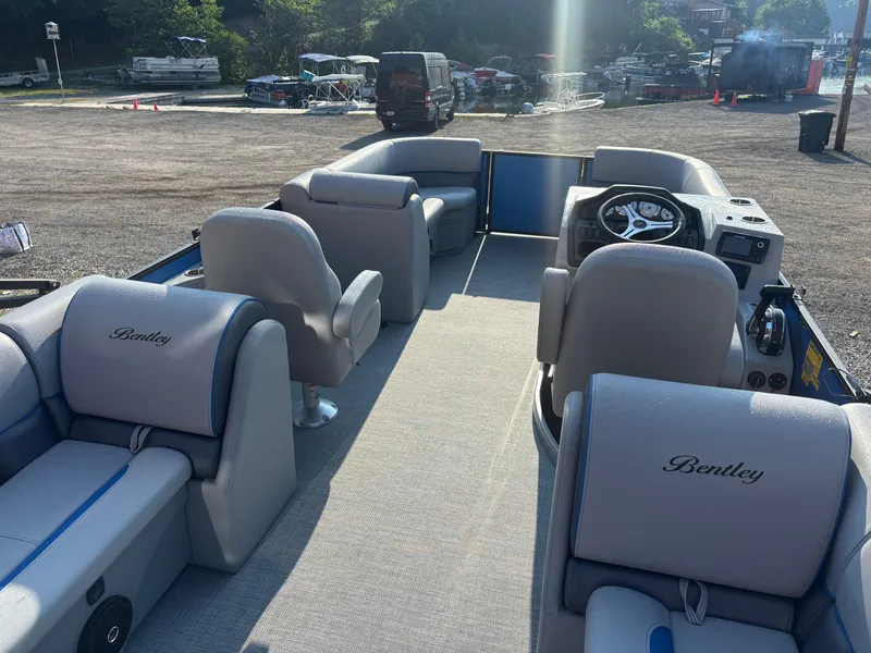 Slide: The Image of 2025 Bentley Pontoons Legacy Navigator interior with plush seating and modern steering console. - 5