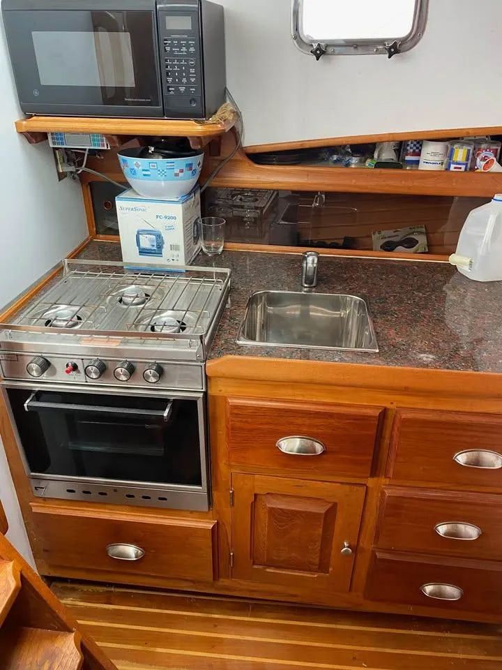 Slide: The Image of Compact kitchen in 2003 Duffy 35 Downeast Flybridge Cruiser with stove, sink, and microwave. - 11