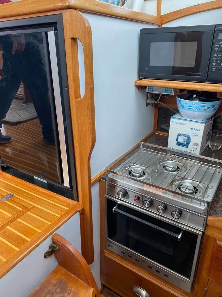 Slide: The Image of Compact kitchen area in a 2003 Duffy 35 Downeast Flybridge Cruiser with stove and microwave. - 12