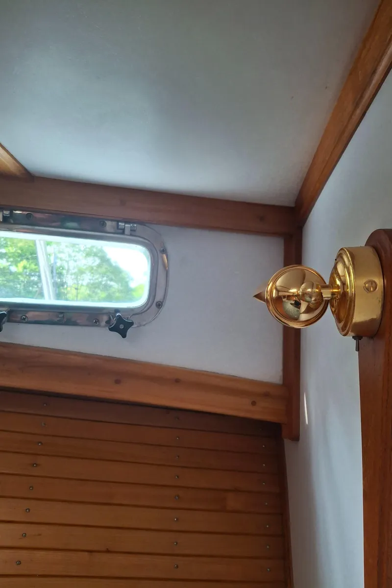 Slide: The Image of Interior of 2003 Duffy 35 Downeast Flybridge Cruiser with brass light fixture and porthole. - 14