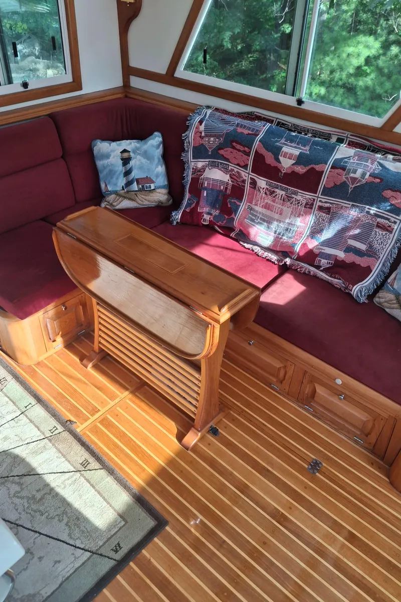 Slide: The Image of Interior of 2003 Duffy 35 Downeast Flybridge Cruiser with red seating and wooden table. - 18