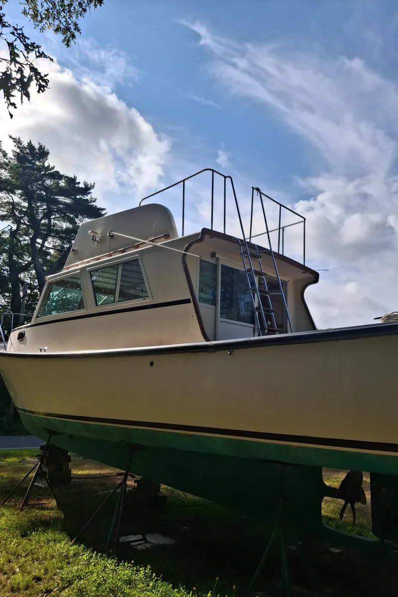 Slide: The Image of 2003 Duffy 35 Downeast Flybridge Cruiser on land, under a blue sky with clouds. - 19