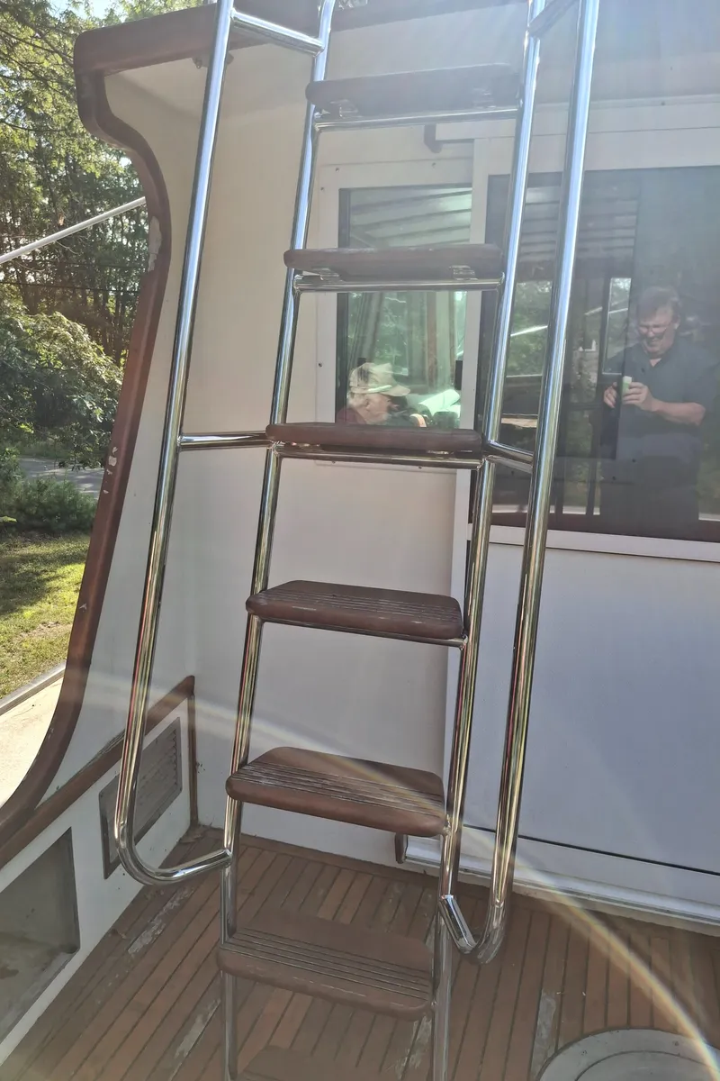 Slide: The Image of Stainless steel ladder on 2003 Duffy 35 Downeast Flybridge Cruiser, wooden steps, outdoor setting. - 22