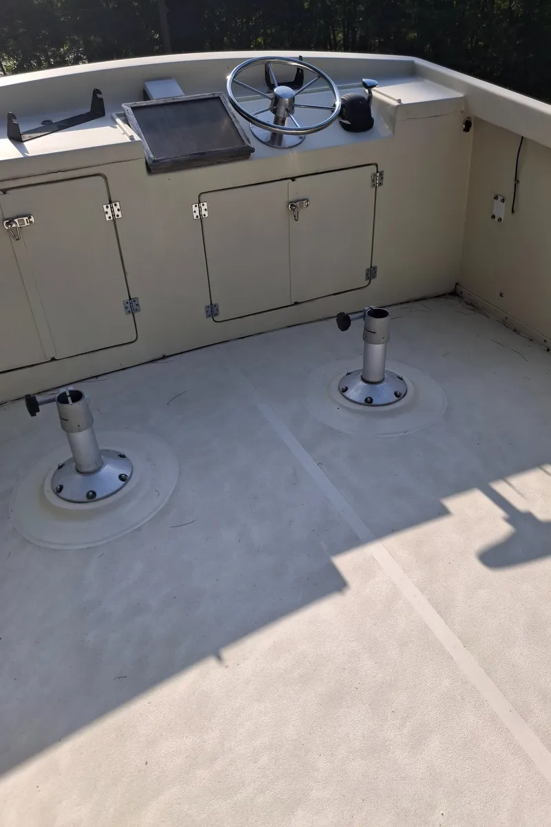 Slide: The Image of 2003 Duffy 35 Downeast Flybridge Cruiser helm with steering wheel and storage compartments. - 24