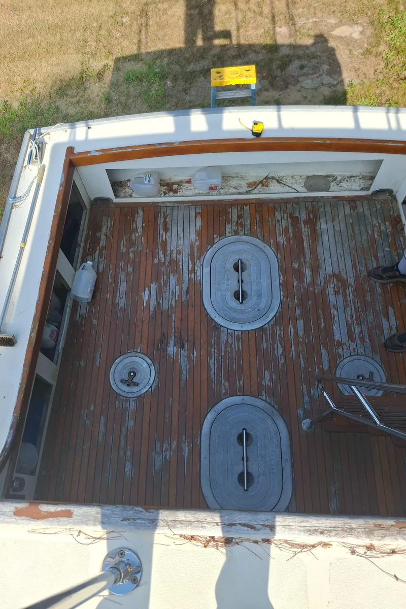 Slide: The Image of 2003 Duffy 35 Downeast Flybridge Cruiser deck with weathered wood and metal hatches. - 26