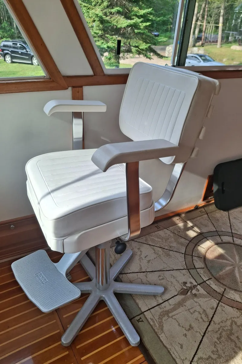 Slide: The Image of White captain's chair on a 2003 Duffy 35 Downeast Flybridge Cruiser, with wooden flooring. - 28