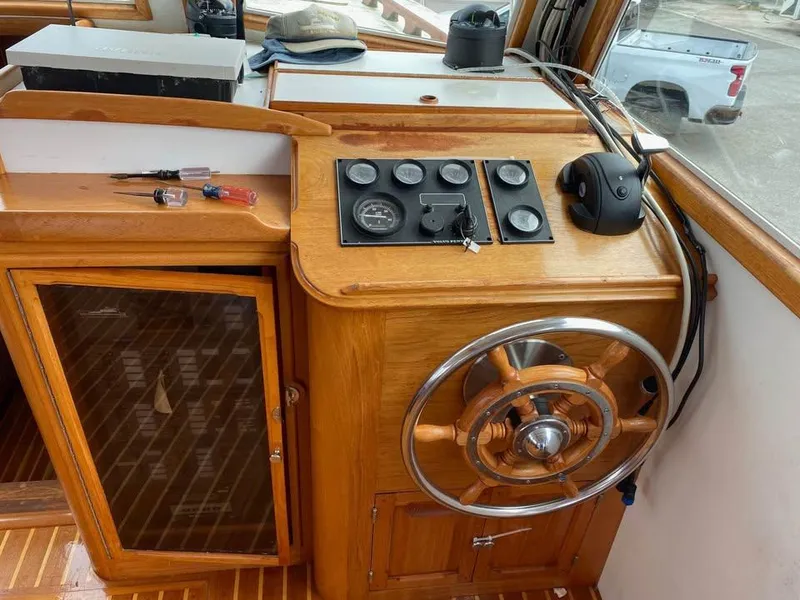 Slide: The Image of 2003 Duffy 35 Downeast Flybridge Cruiser helm with wooden steering wheel and control panel. - 3