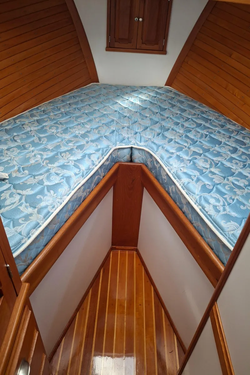 Slide: The Image of 2003 Duffy 35 Downeast Flybridge Cruiser cabin with wooden interior and blue patterned mattress. - 6