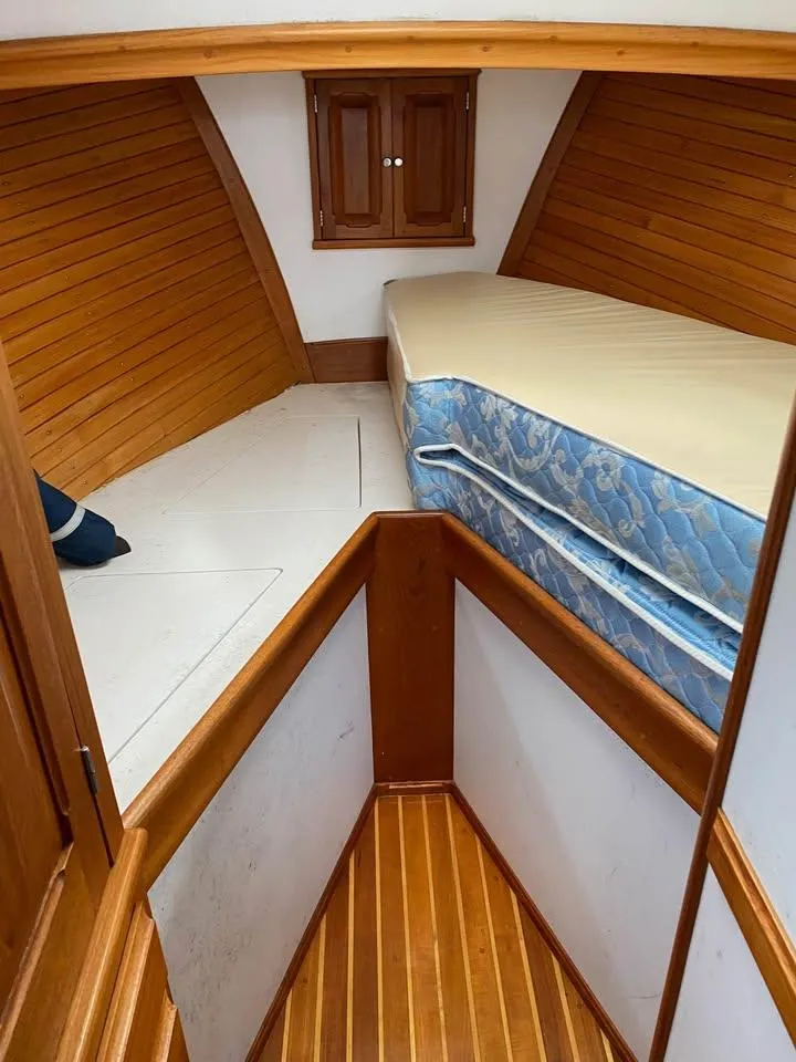 Slide: The Image of Interior cabin of 2003 Duffy 35 Downeast Flybridge Cruiser with wooden paneling and mattress. - 7