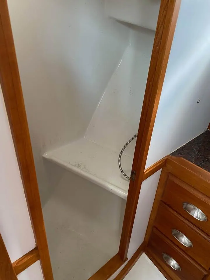 Slide: The Image of 2003 Duffy 35 Downeast Flybridge Cruiser interior shower with wooden trim and storage drawers. - 9