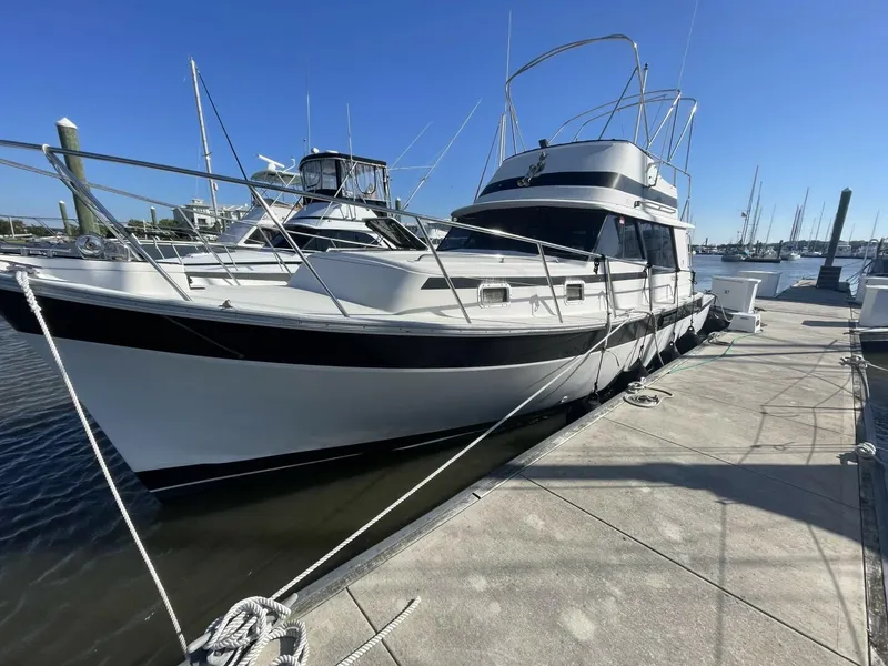 Slide: The Image of 1984 Mainship MK III boat docked at marina under clear blue sky. - 1