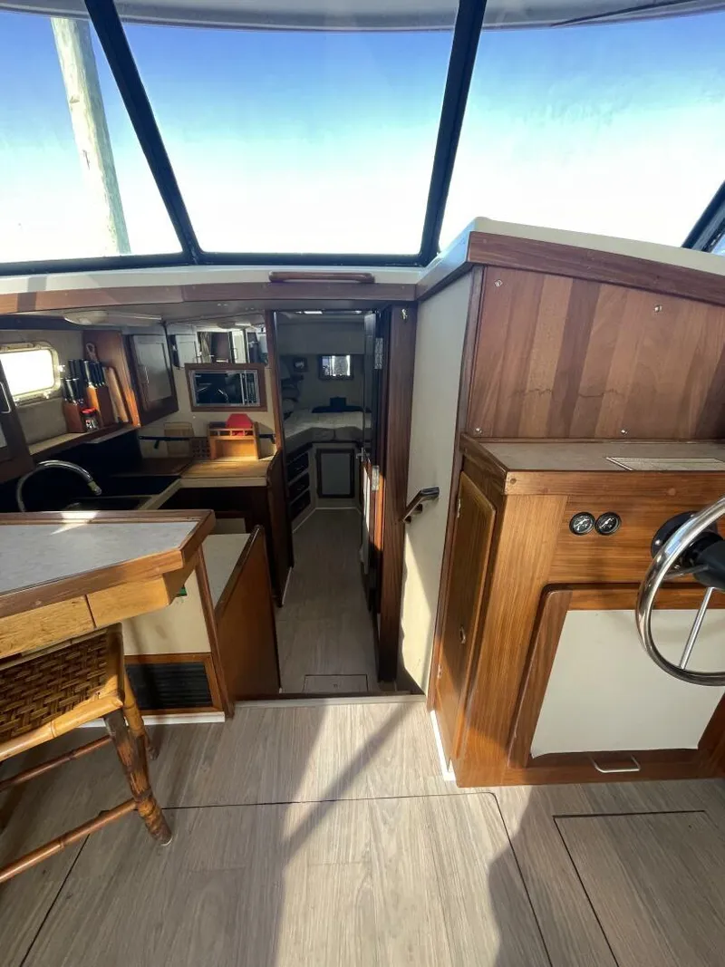 Slide: The Image of 1984 Mainship MK III interior with wood accents and modern amenities. - 11