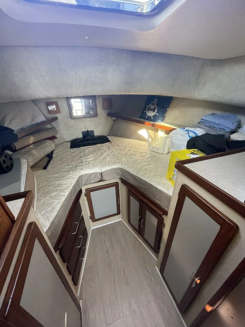 Slide: The Image of 1984 Mainship MK III cabin interior with bed, storage, and natural light. - 17