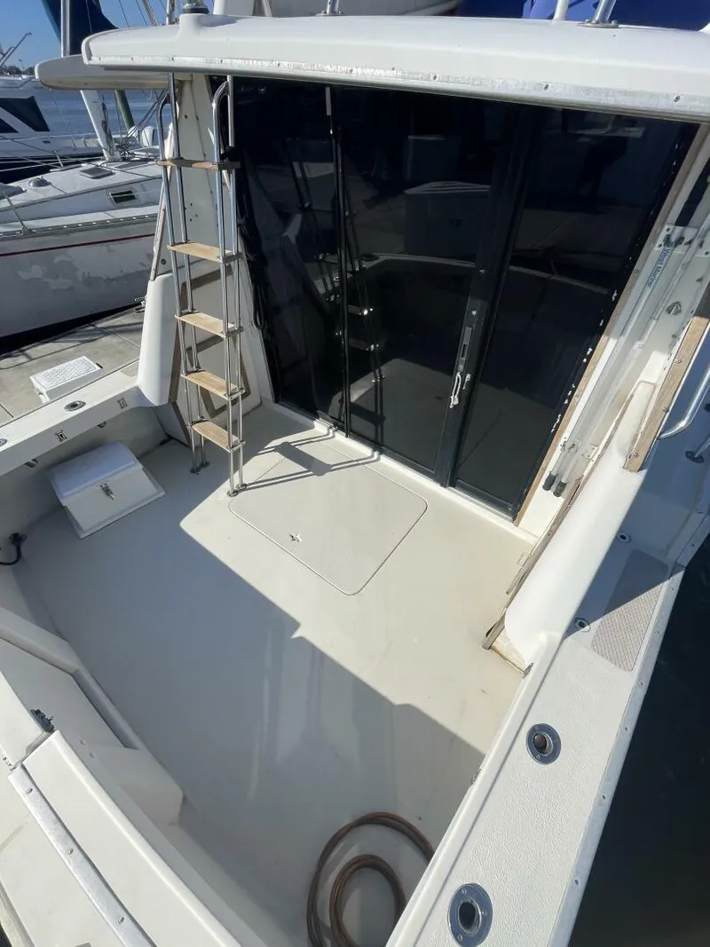 Slide: The Image of 1984 Mainship MK III boat deck with ladder and sliding glass doors. - 19