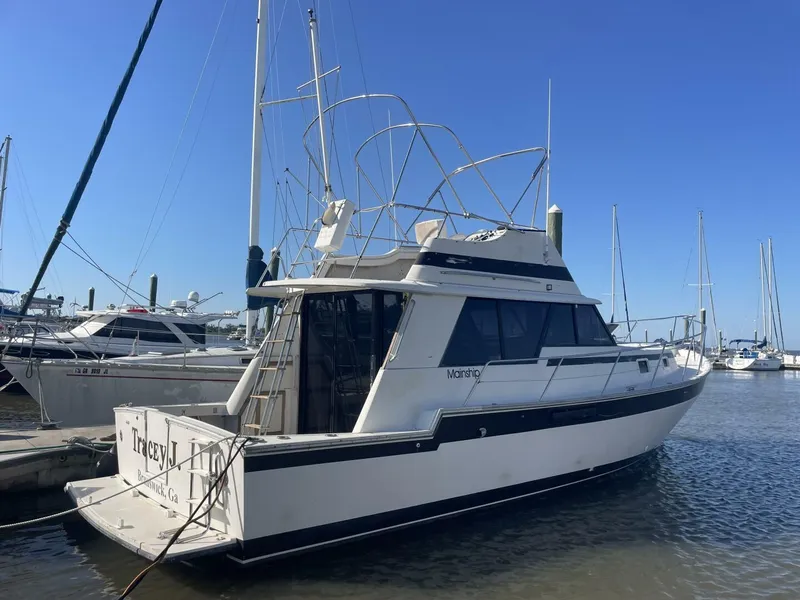 Slide: The Image of 1984 Mainship MK III yacht docked at marina under clear blue sky. - 2