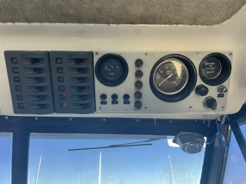 Slide: The Image of 1984 Mainship MK III dashboard with gauges and switches, including fuel and RPM indicators. - 25