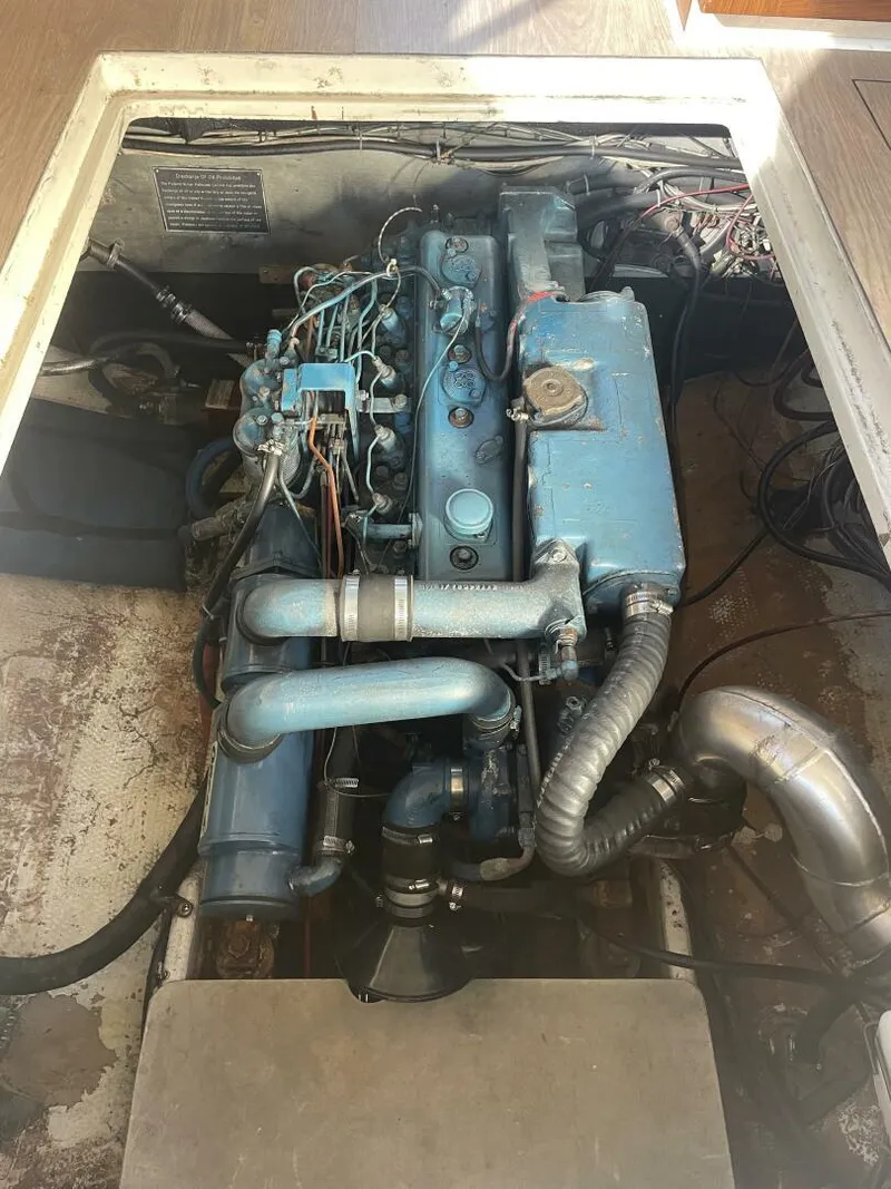 Slide: The Image of 1984 Mainship MK III engine compartment with visible blue engine components and wiring. - 31