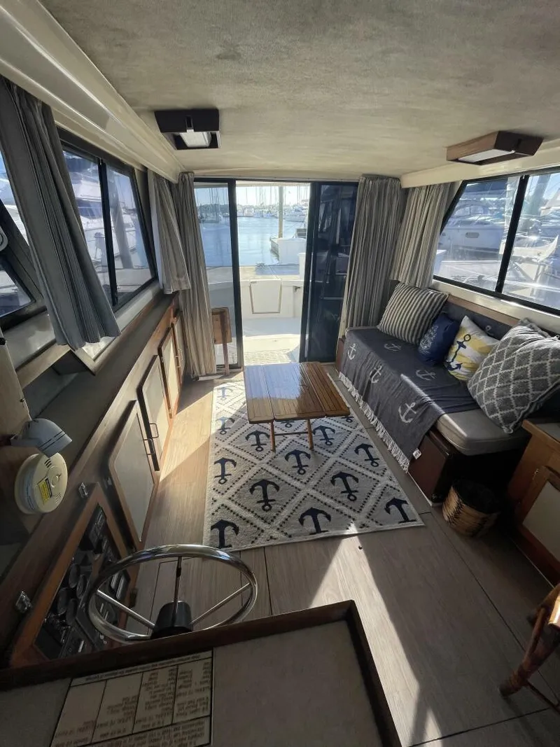 Slide: The Image of Interior of 1984 Mainship MK III boat with nautical decor and waterfront view. - 9
