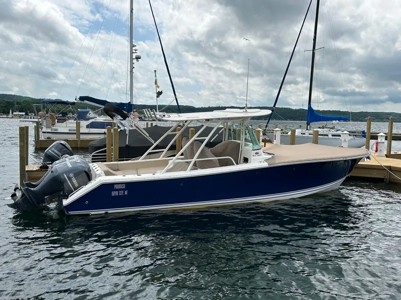 The Image of 2015 Pursuit ST 310 Sport boat docked at marina with Yamaha engines. - 0