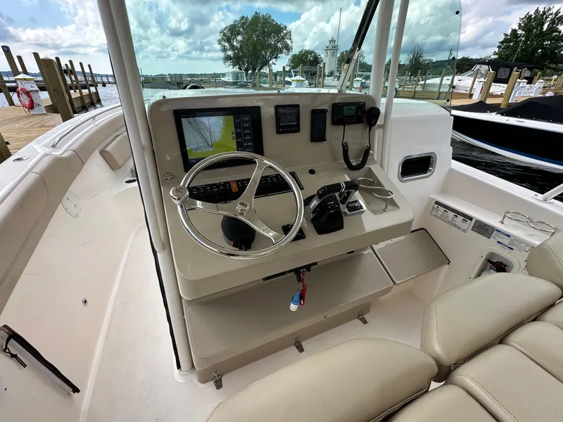 Slide: The Image of 2015 Pursuit ST 310 Sport boat dashboard with steering wheel and navigation equipment. - 10