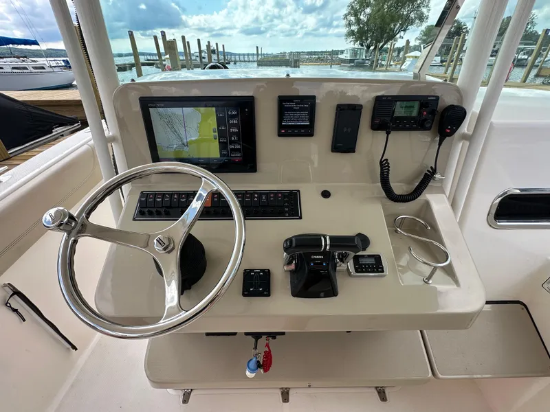 Slide: The Image of Control panel of 2015 Pursuit ST 310 Sport boat with steering wheel and navigation equipment. - 12