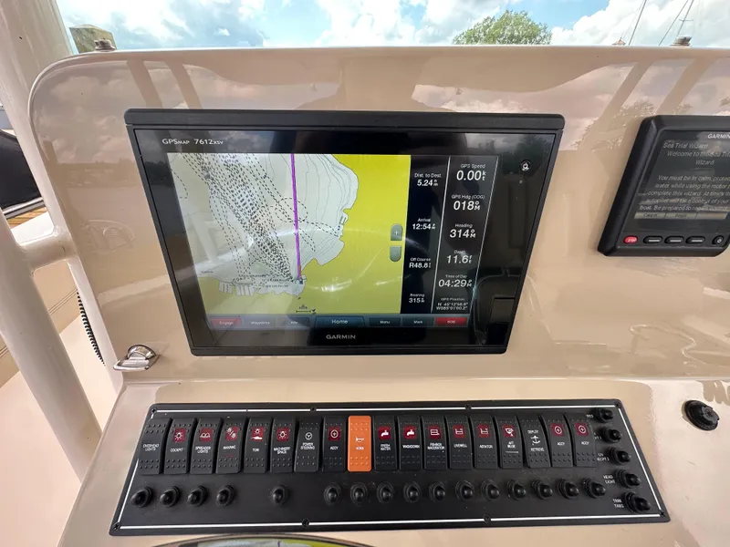 Slide: The Image of Garmin GPS display on 2015 Pursuit ST 310 Sport boat dashboard with control panel. - 13